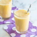 Delicious banana smoothie ingredients including banana, yogurt, and milk in a blender.