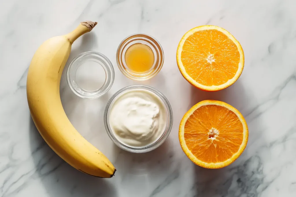 Flat lay of banana smoothie ingredients on white marble.