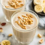 Healthy banana smoothie made with ripe bananas and coconut milk, topped with cinnamon.
