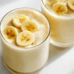 Easy Banana Smoothie in a chilled glass with banana slice and straw