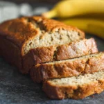 Healthy banana bread loaf with slices on parchment board