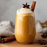 Healthy Pumpkin Smoothie in a tall glass with cinnamon and straw.