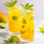 Mango Mojito Mocktail in a tall glass with mint, lime, and ice