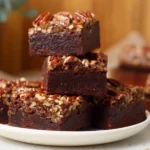 Freshly baked Pecan Pie Brownies with glossy pecan topping