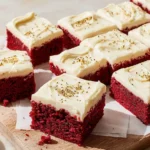 Red velvet sheet cake topped with cream cheese frosting and sprinkles