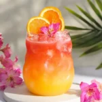 Tropical mocktail with mango, pineapple, coconut water and hibiscus over ice.