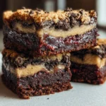 A stack of amazing slutty brownies with layers of fudge, cookie dough, and Oreos.
