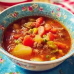 Bowl of delicious beef vegetable soup with colorful vegetables and tender beef