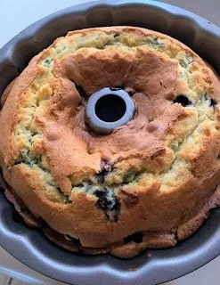 Slice of blueberry sour cream coffee cake with fresh blueberries on top