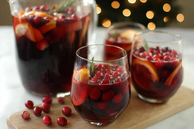 Glass of vibrant Christmas Sangria with festive fruits and spices