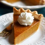 Slice of easy pumpkin pie topped with whipped cream on a plate