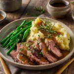Ribeye steak with roasted garlic sauce served with mashed potatoes and green beans