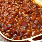 Southern-style baked beans with bacon served in a rustic bowl