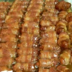 Bacon Wrapped Smokies topped with brown sugar and butter, served as a tasty appetizer.