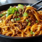 Mongolian ground beef noodles served with fresh vegetables and spices