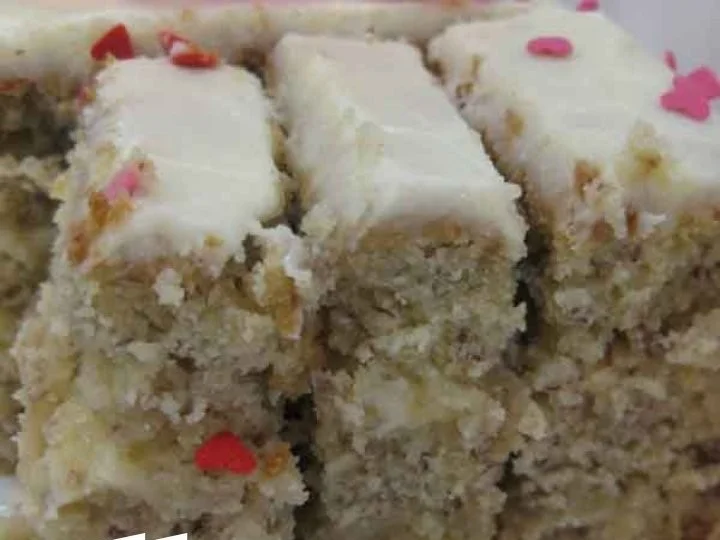 Delicious homemade banana cake topped with frosting and banana slices