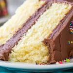Delicious homemade vanilla cake topped with creamy frosting and fresh berries.