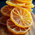A plate of beautifully arranged candied oranges with a glossy finish.