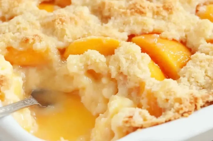 Homemade easy peach cobbler served in a rustic dish with a golden crust.