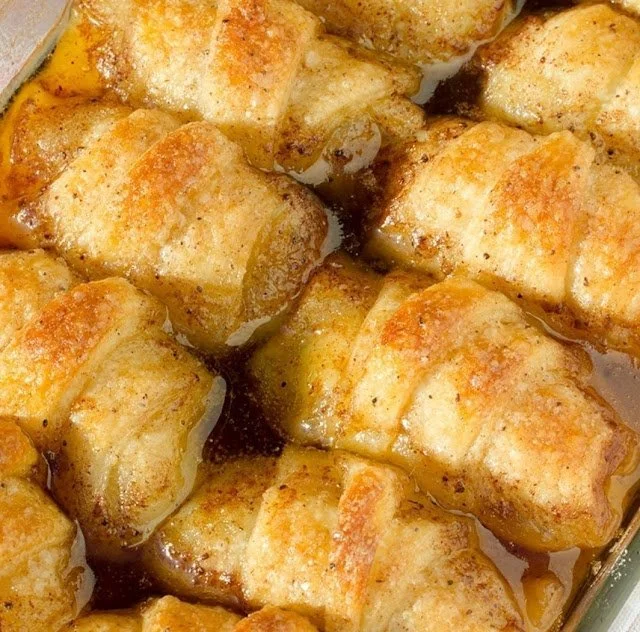 Freshly baked cinnamon apple dumplings topped with caramel sauce