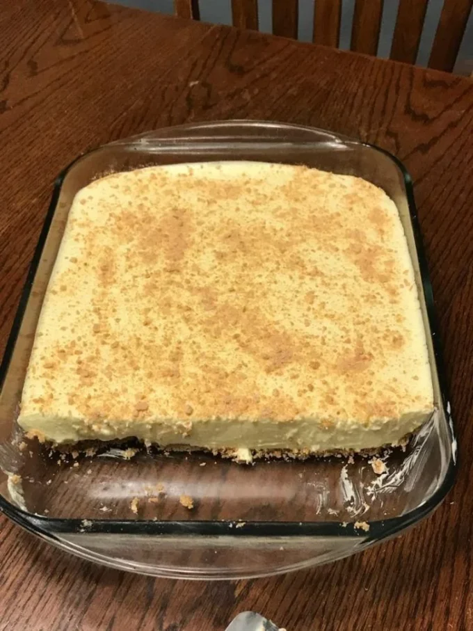Lemon Jello Cream Cheese Dessert in a glass, garnished with lemon zest