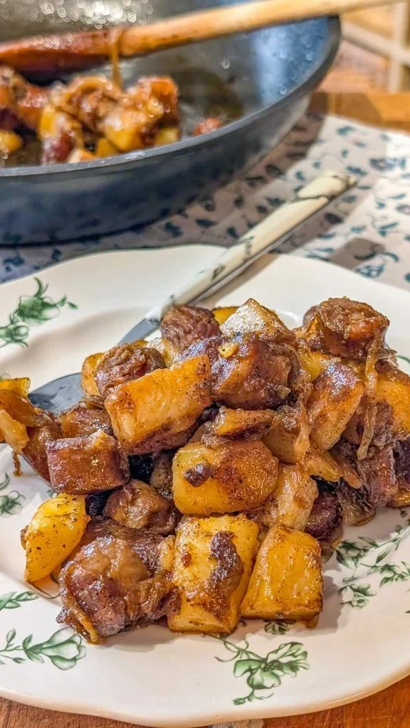 Plate of fried potatoes with onions and Polish sausage, a hearty meal option