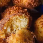 Delicious homemade hush puppies served with dipping sauce on a plate.