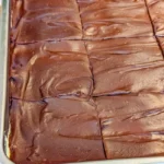 No bake chocolate eclair cake topped with chocolate icing and whipped cream.