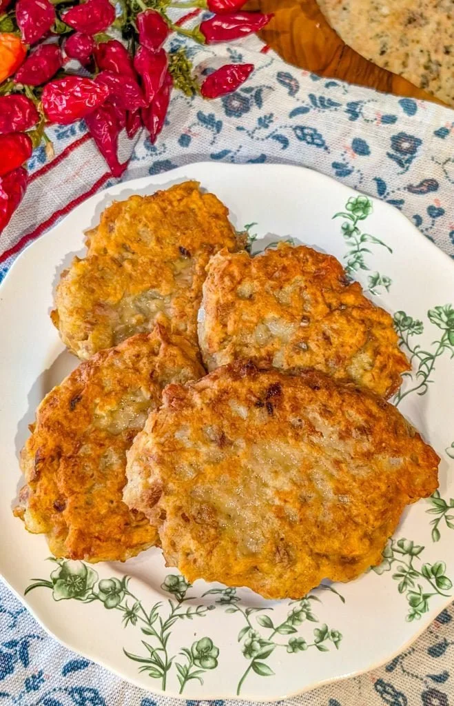 Southern fried salmon patties served on a plate with lemon wedges.