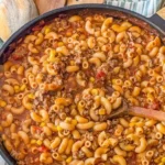 A delicious bowl of homemade goulash topped with herbs and served with bread.